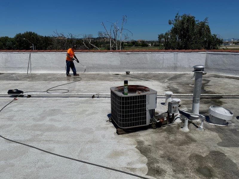 Photo of a dirty roof being power washed