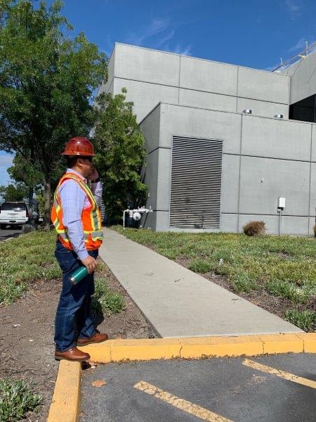 Photo of Rafael on a jobsite standing in his hard hat safety vest